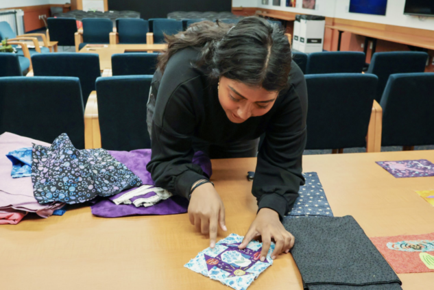 Swati Ravi pointing out details on a quilt square
